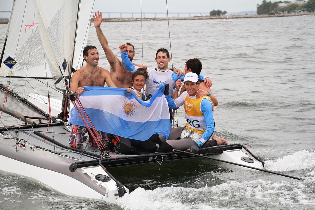 Swimmers (Including family) come out to Santiago Lange and Cecilia Saroli after their Gold medal win in the Nacra17 class. Medal race 2916 Summer Olympics © Richard Gladwell www.photosport.co.nz